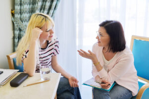 A teen is speaking with a therapist and participating in social anxiety treatment for teens.