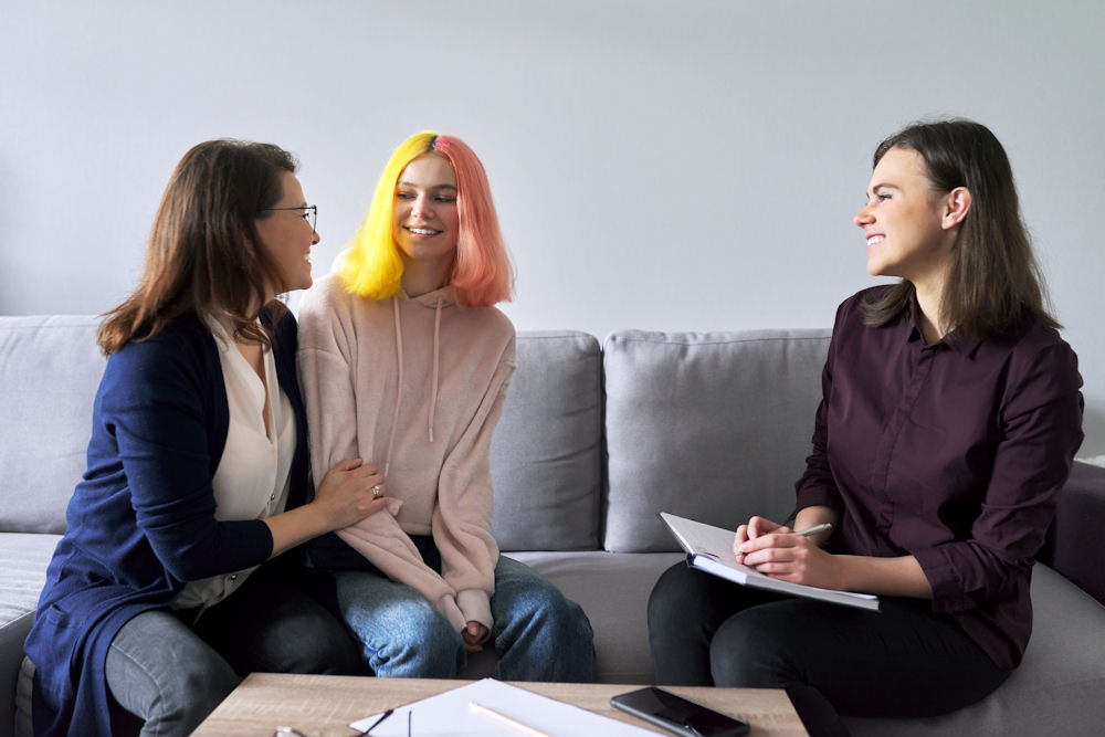 parent offering emotional support to teen during a therapy session for social anxiety