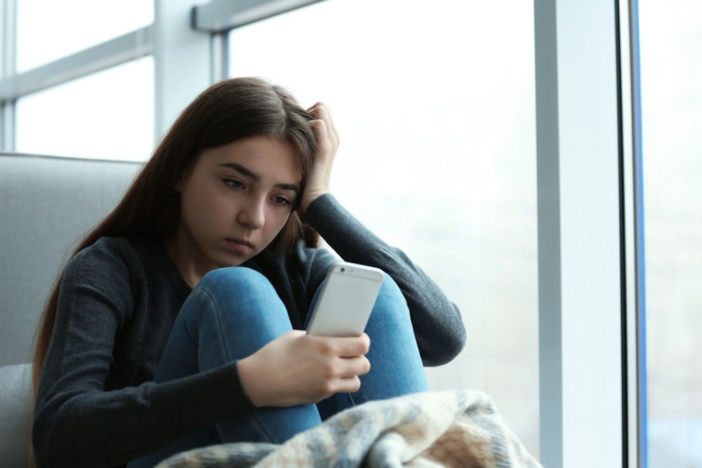 a teenager staring at her phone