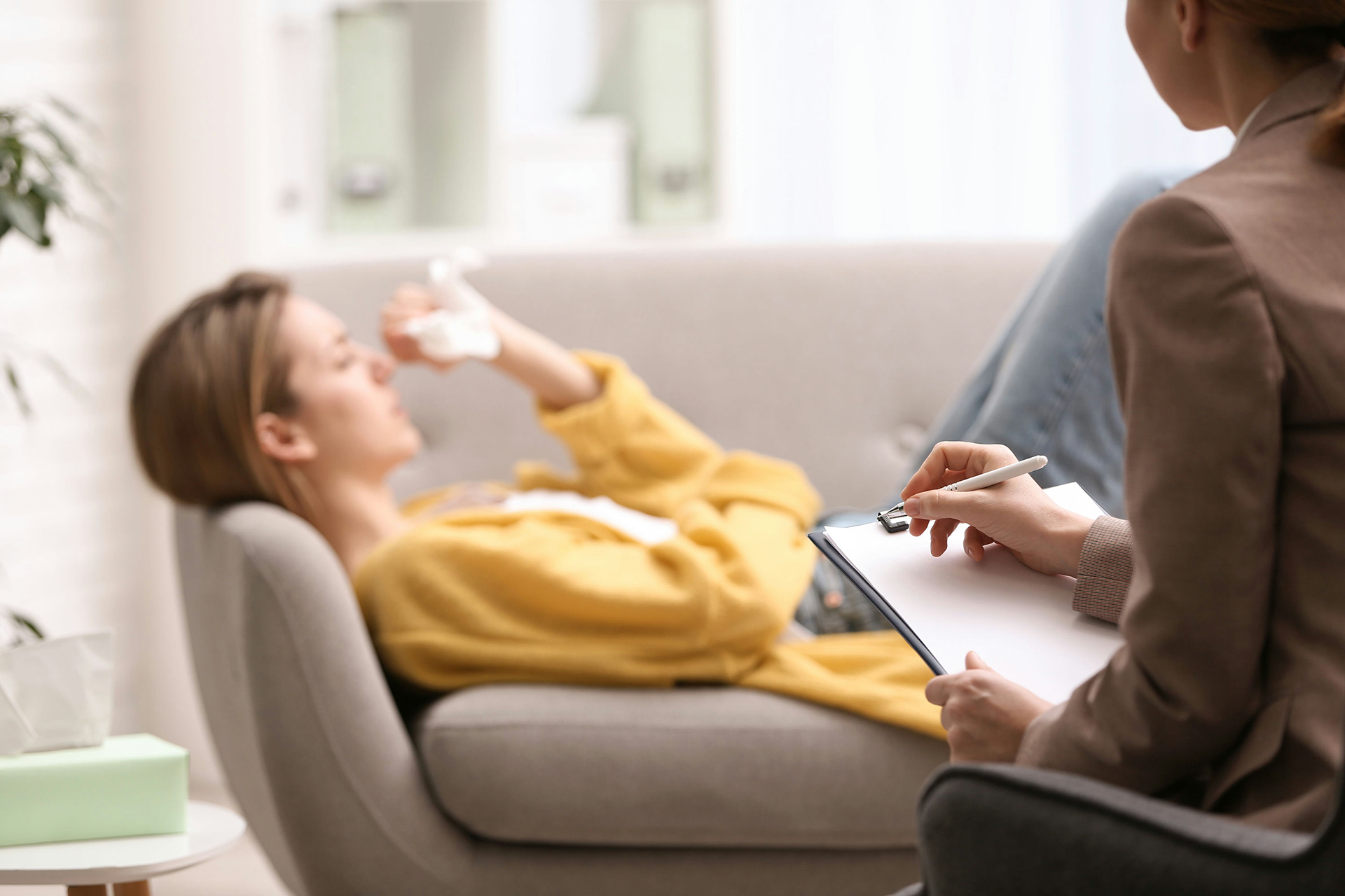 Teen in therapy session discussing PTSD and addiction recovery with a trauma-informed counselor.