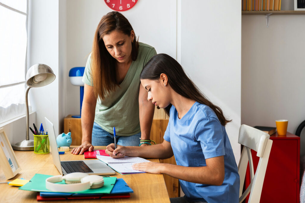 Ohio teen with ADHD struggling to focus on schoolwork while parent offers support