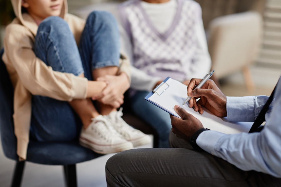 Teen holding knees during therapy for teens.