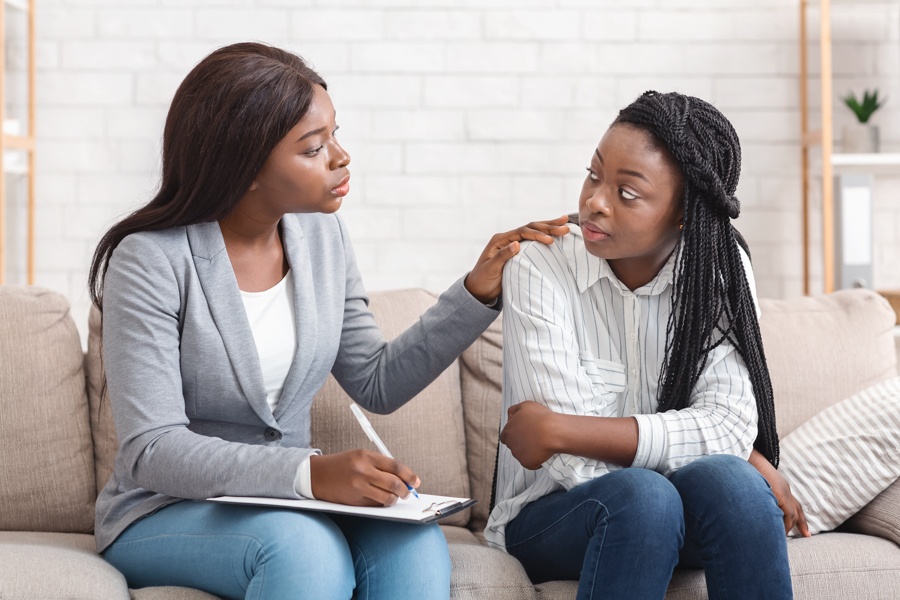 Therapist reassuring young teenager during therapy session near Columbus, OH.